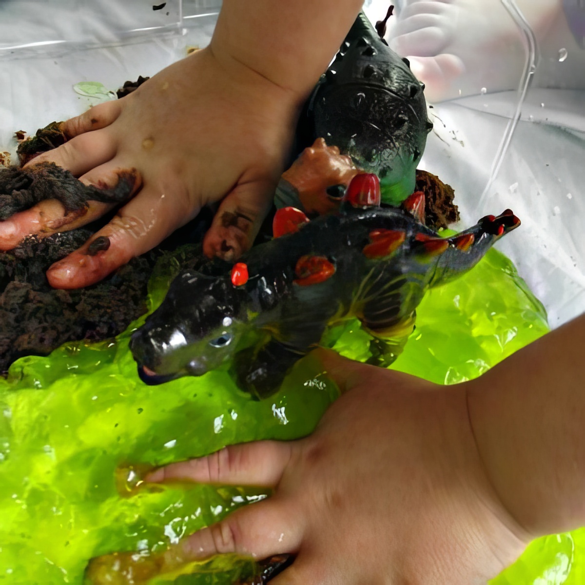 kid's hands submerged in jelly as sensory bins for preschoolers
