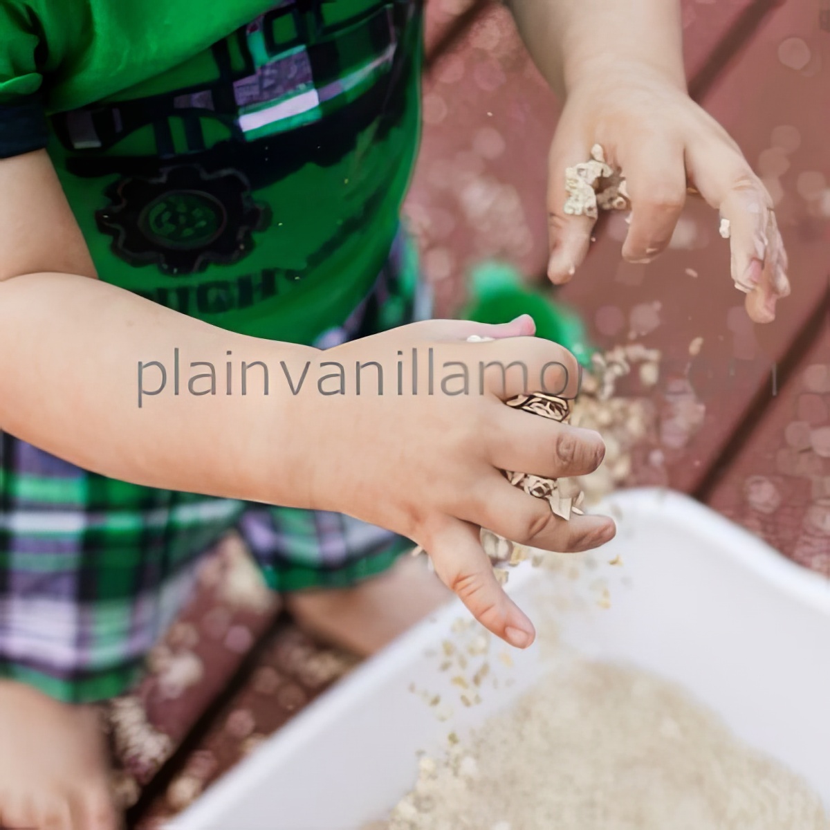kid playing with watered down oatmeal in a bin as sensory bins for preschoolers