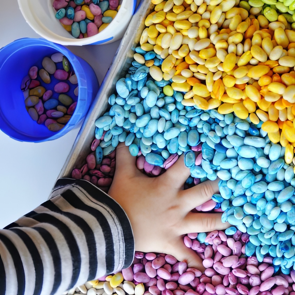 scented rainbow beans as sensory bins for preschoolers - dyed beans in a plastic bin