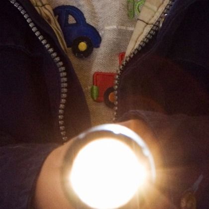 kid holding a flashlight as outdoor games to burn off steam