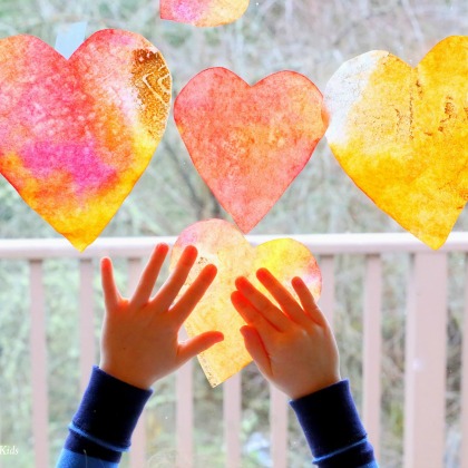 Heart Suncatcher Craft - cut out heart shapes with varied colors of paint on a window glass