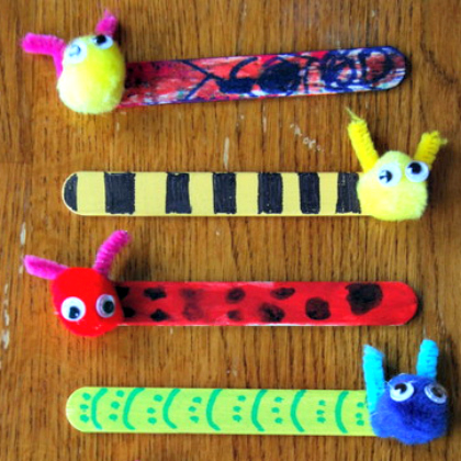 bookmark buddies made of popsicle sticks and pom poms finished with markers