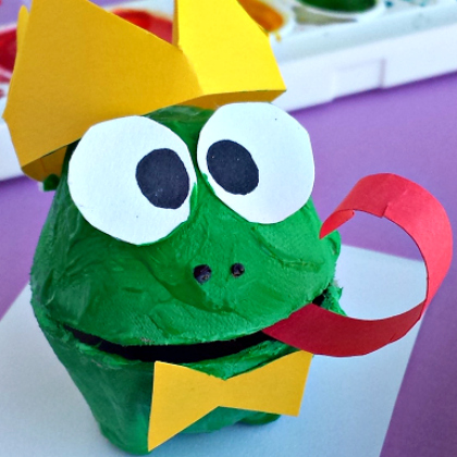 green frog prince made of egg carton with yellow crown, yellow bow tie and red tongue stuck out.