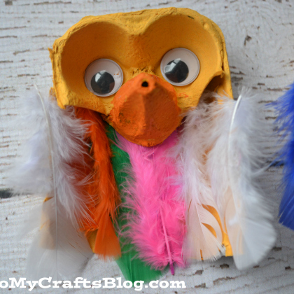 Egg Carton Owl with colorful feathers of white, orange, green, pink and yellow. 