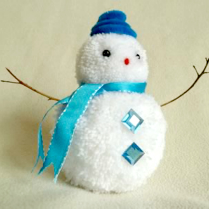 Snowman Pom Pom Craft for Kids with blue hat, blue riboon scarf, diamond charms and twigs for hands