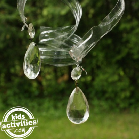 water bottle crafts for kids from Kids Activities Blog - shown is a finished water bottle craft of spiral water bottle with prisms blowing in the wind