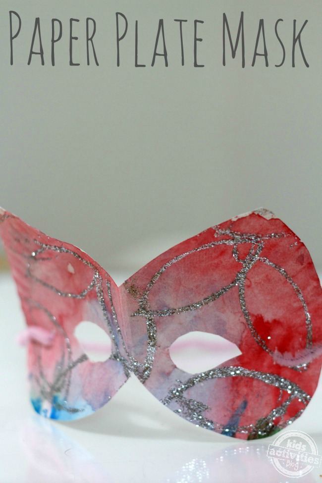 shown is a finished paper plate mask craft with colorful background and sparkled glitter