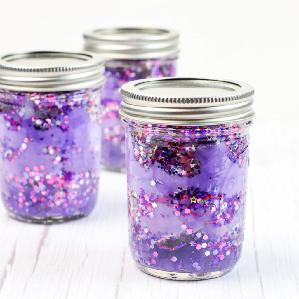 Three colorful galaxy jars with glitter.